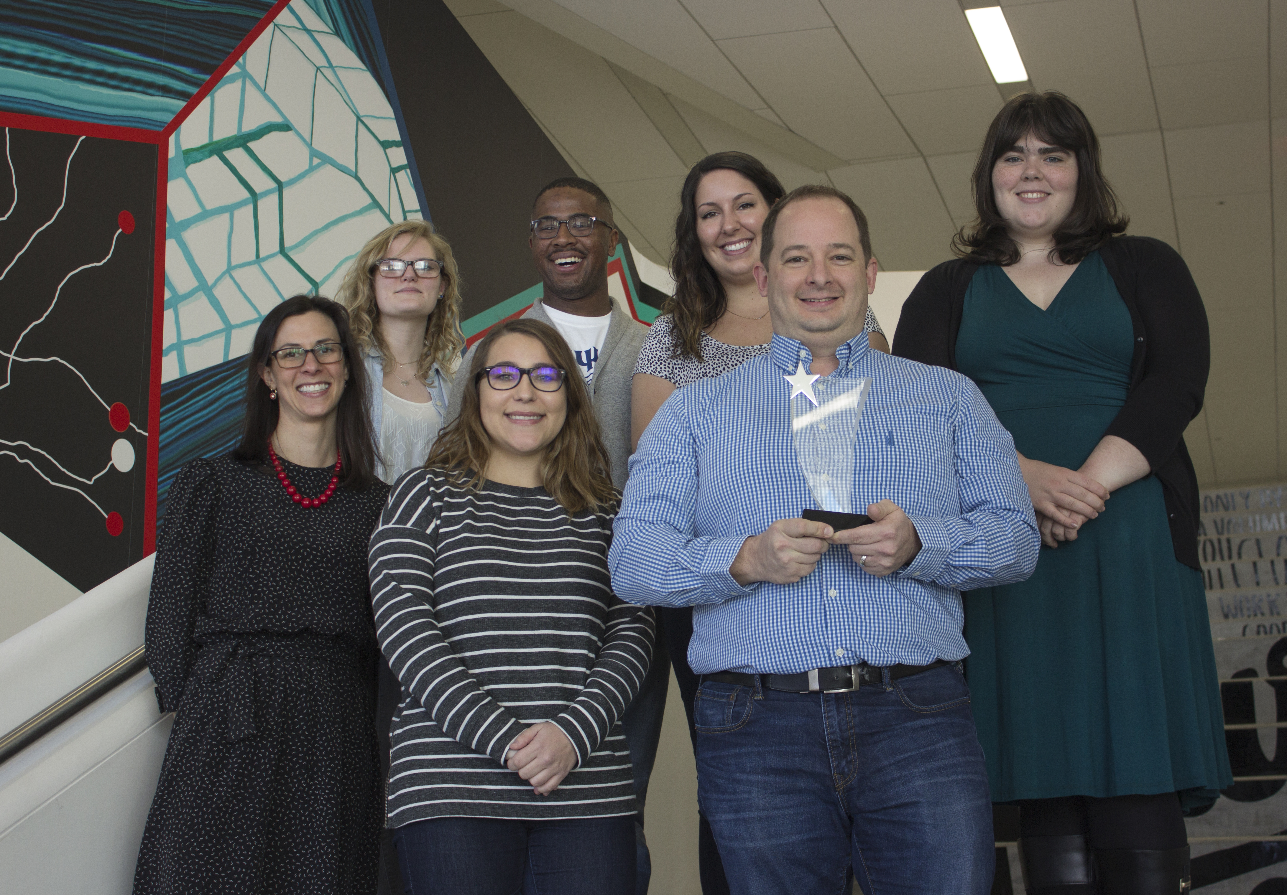 Jonathan Boulter and his team standing on steps with his award.