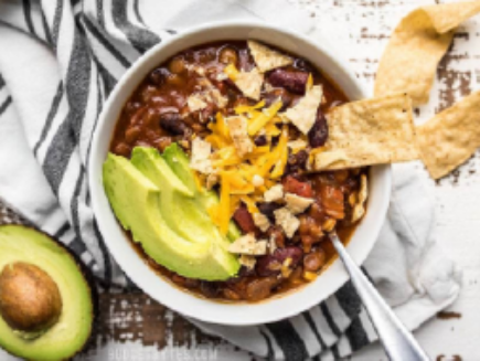 chili with avocado and shredded cheese