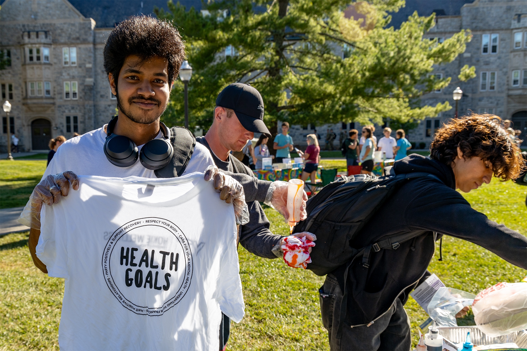 Student holding up a shirt with the words "Healthy Goals"